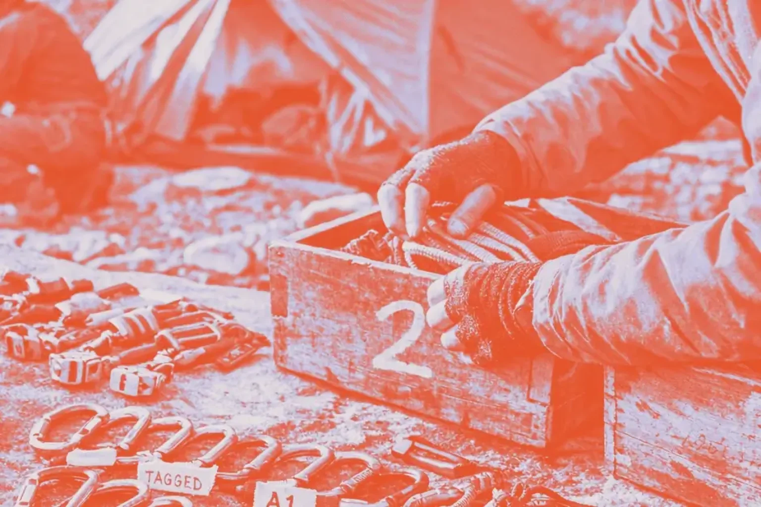 Climbing gear including ropes, carabiners, and a checklist is spread out on a rock surface.